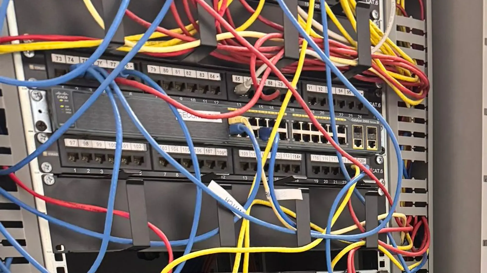 Armadio rack con patch panel numerati, switch e cavi di rete attestati